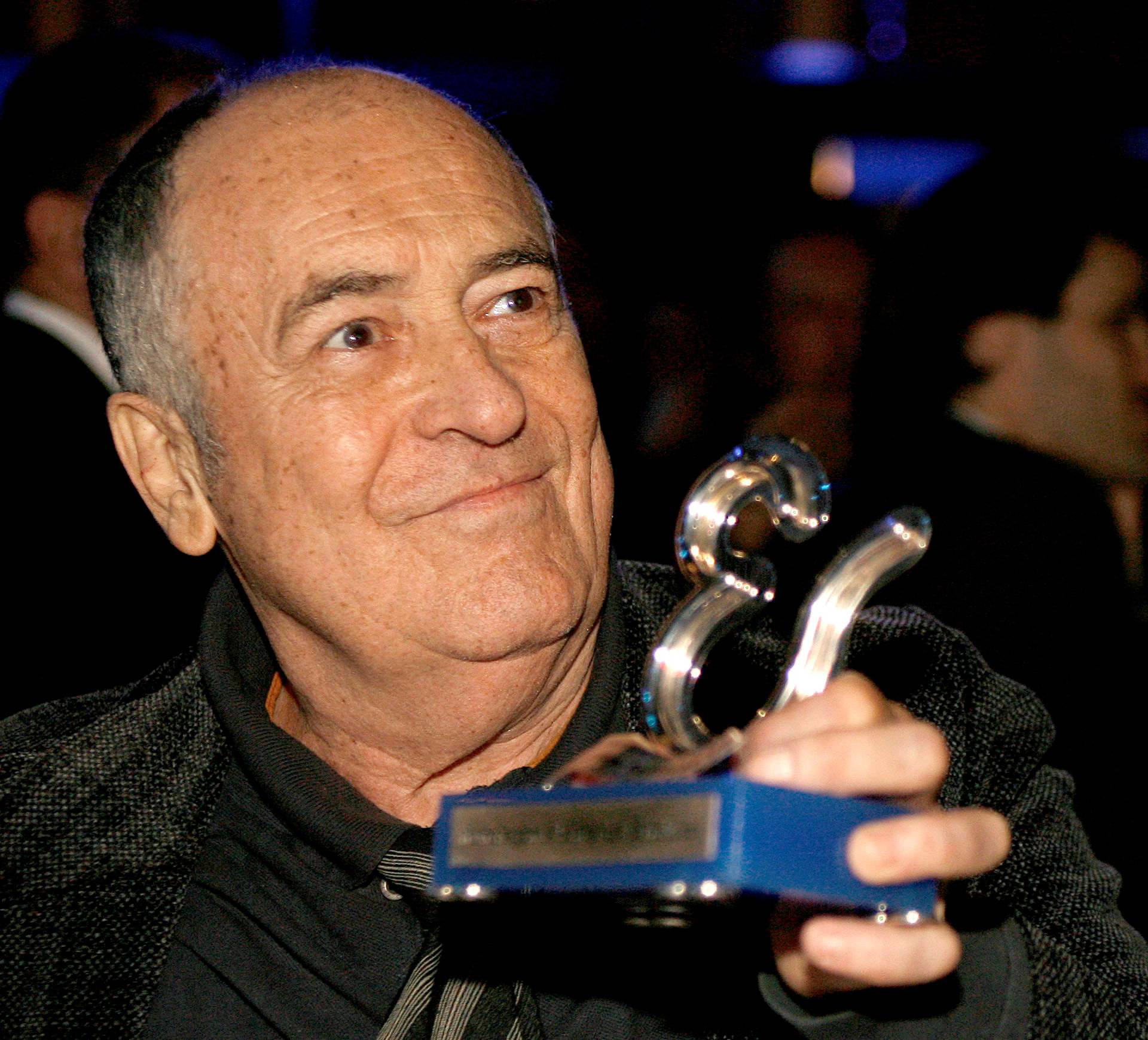 FILE PHOTO: Italian director Bernardo Bertolucci holds his honorary award during the Estoril Film Festival in Estoril