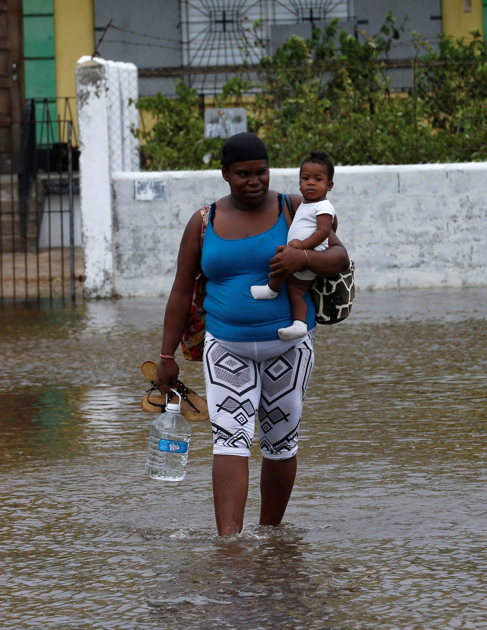 A woman holds her son as she leaves at a school used as a shelter, after Hurricane Earl hit, in Belize City