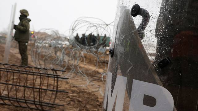 FILE PHOTO: Workers work at construction site of barrier at border between Poland and Belarus