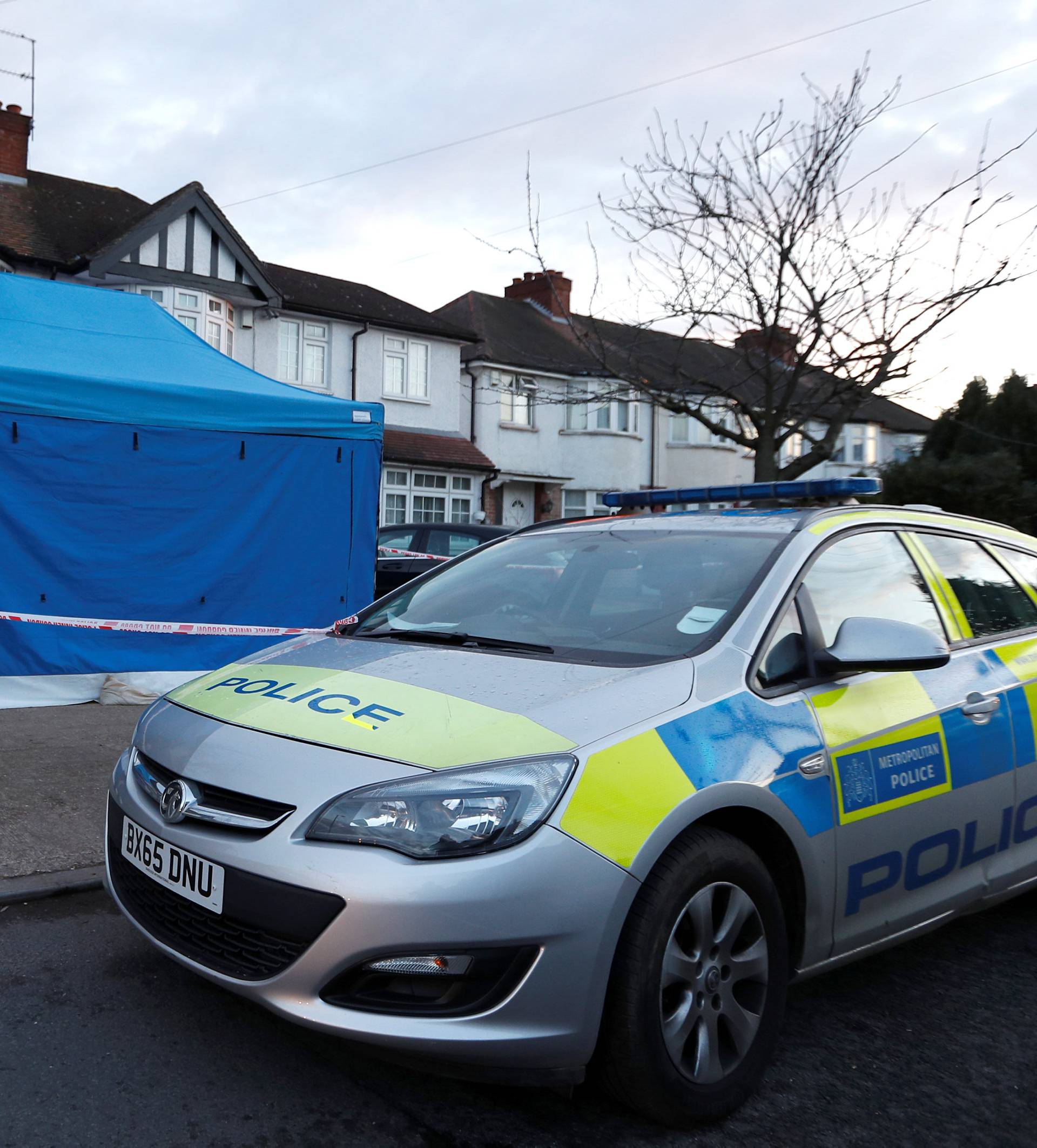 A police officer stands guard outside the home of Nikolai Glushkov in New Malden