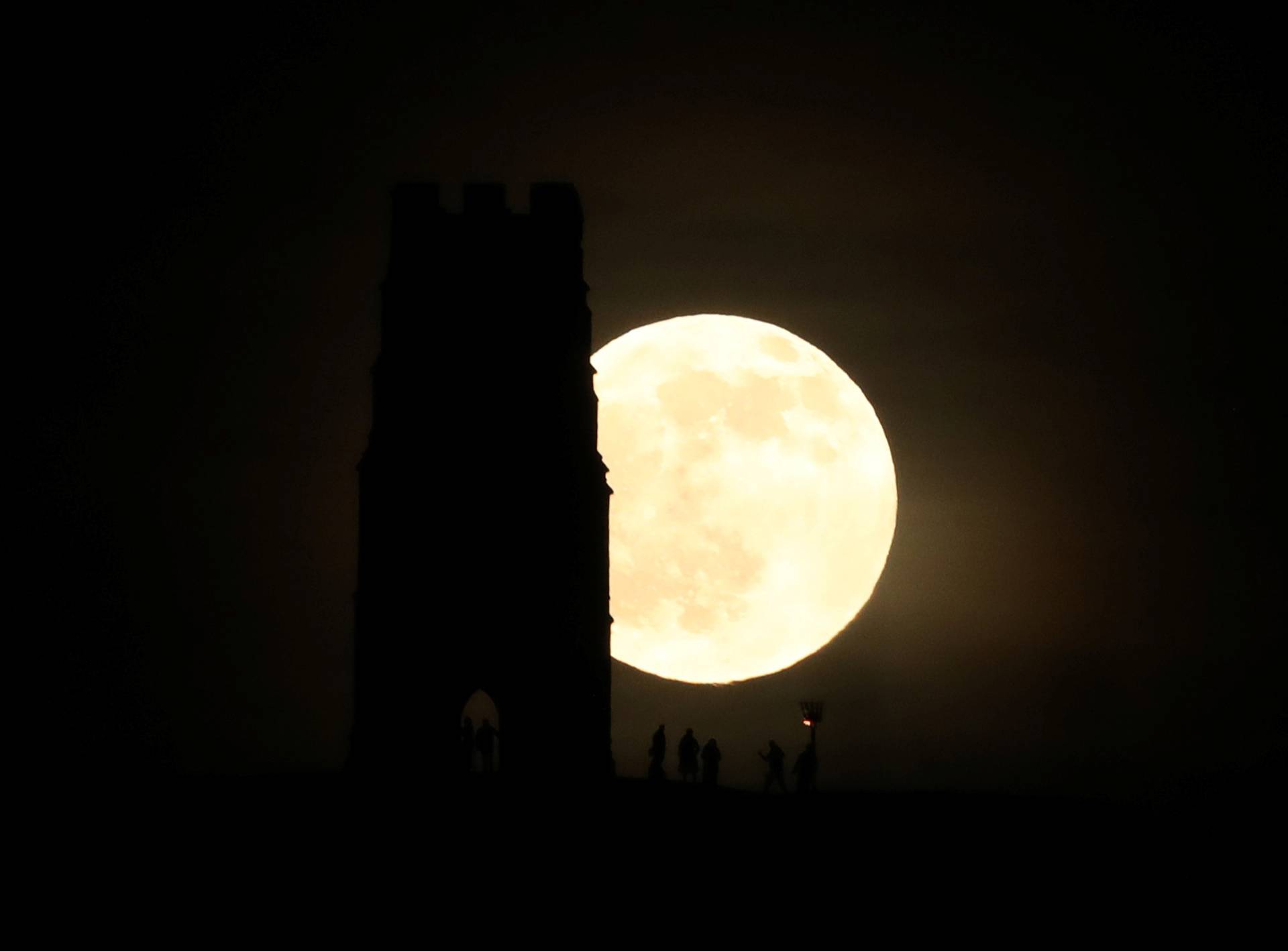 St Michael's Tower is seen on Glastonbury Tor as a full moon rises in Glastonbury