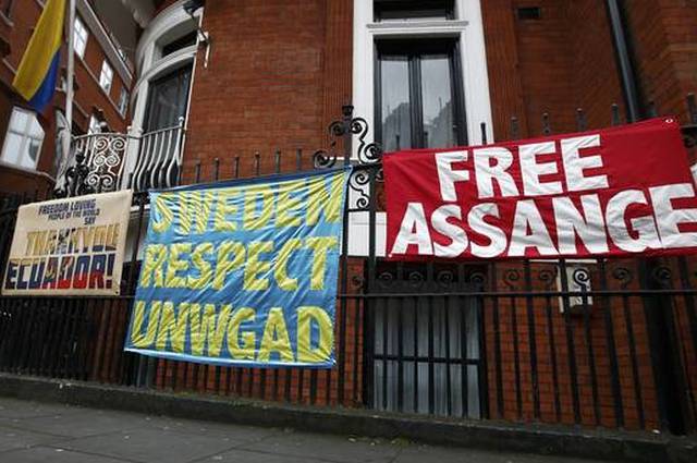 Posters and banners are attached to railings after prosecutor Ingrid Isgren from Sweden arrived at Ecuador's embassy to interview him in London