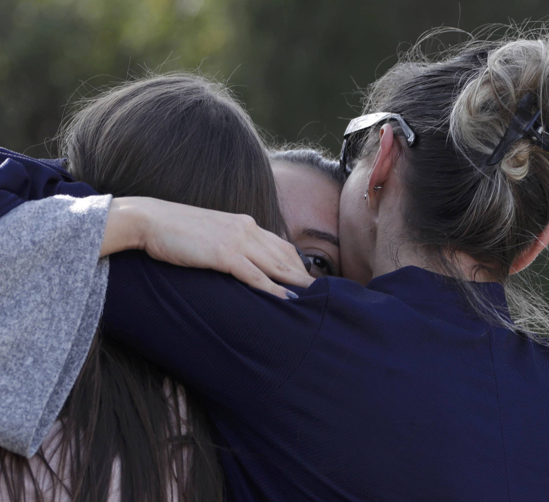 People embrace near the Tocqueville high school after a shooting incident injuring at least eight people, in Grasse, southern France