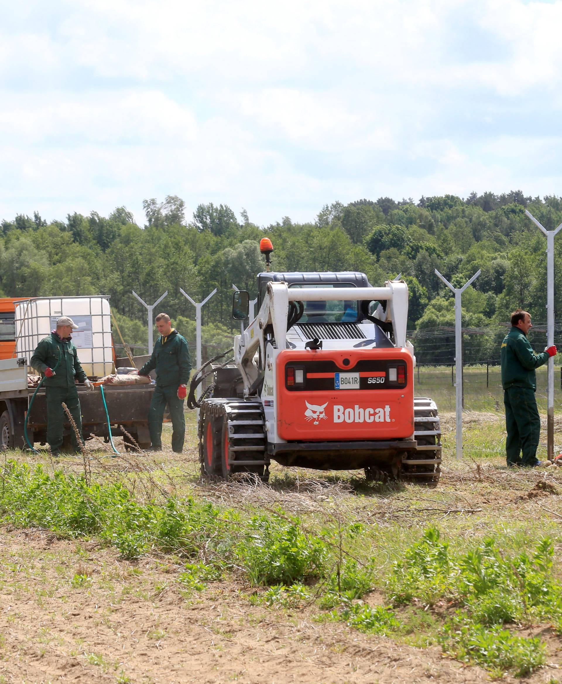 Workers install poles for fence near Sudargas border crossing point with Russia in Ramoniskiai