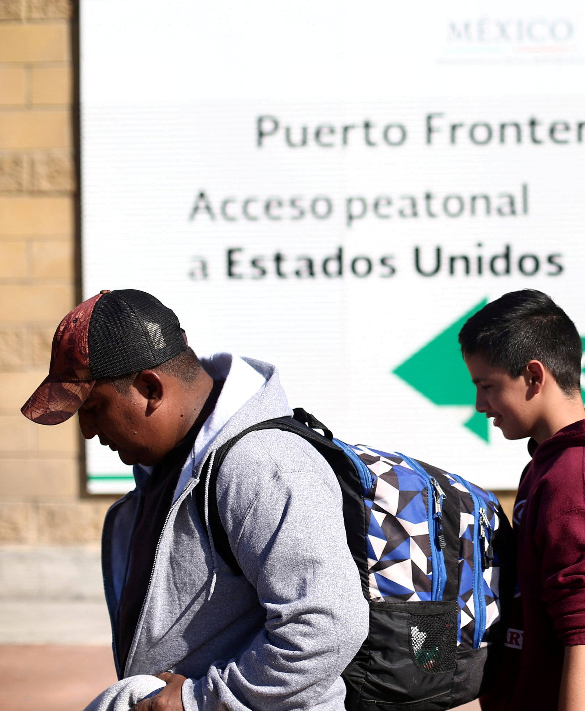 FILE PHOTO: Members of a caravan of migrants from Central America line up to enter the United States border and customs facility in Tijuana