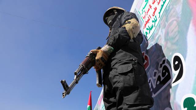 A Houthi fighter stands guard during a ceremony at the end of the training of newly recruited Houthi fighters in Sanaa