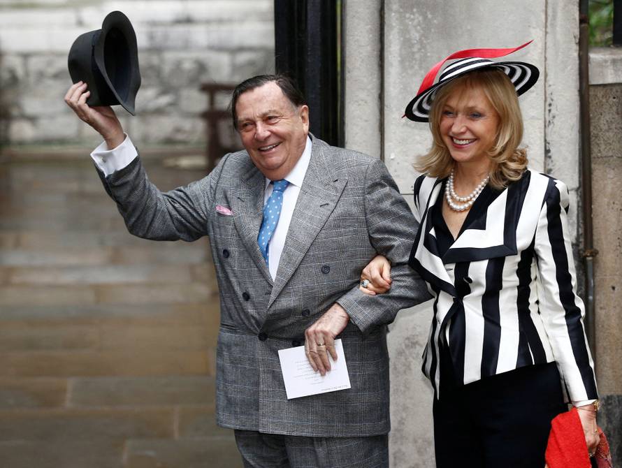 FILE PHOTO: Comedian Barry Humphries and his wife Lizzie Spender pose for a photograph as they arrive at St Bride's church for a service to celebrate the wedding between media Mogul Rupert Murdoch and former supermodel Jerry Hall, in London