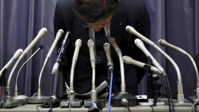 Mitsubishi Motors Corp's President Tetsuro Aikawa bows as he leaves a news conference to brief about issues of misconduct in fuel economy tests at the Land, Infrastructure, Transport and Tourism Ministry in Tokyo