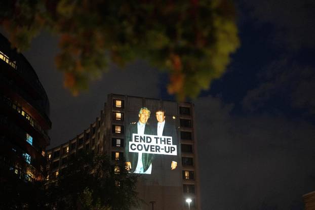 Documents and photos of Jeffrey Epstein and U.S. President Trump projected onto Hilton ahead of WHCA Gala, in Washington, D.C.