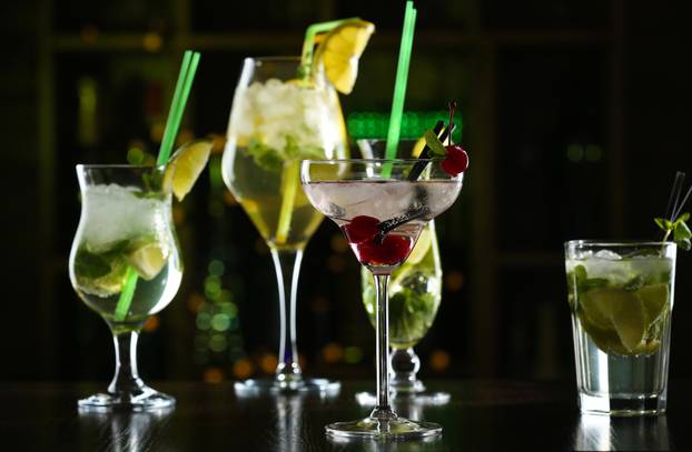 Glasses of cocktails on bar background