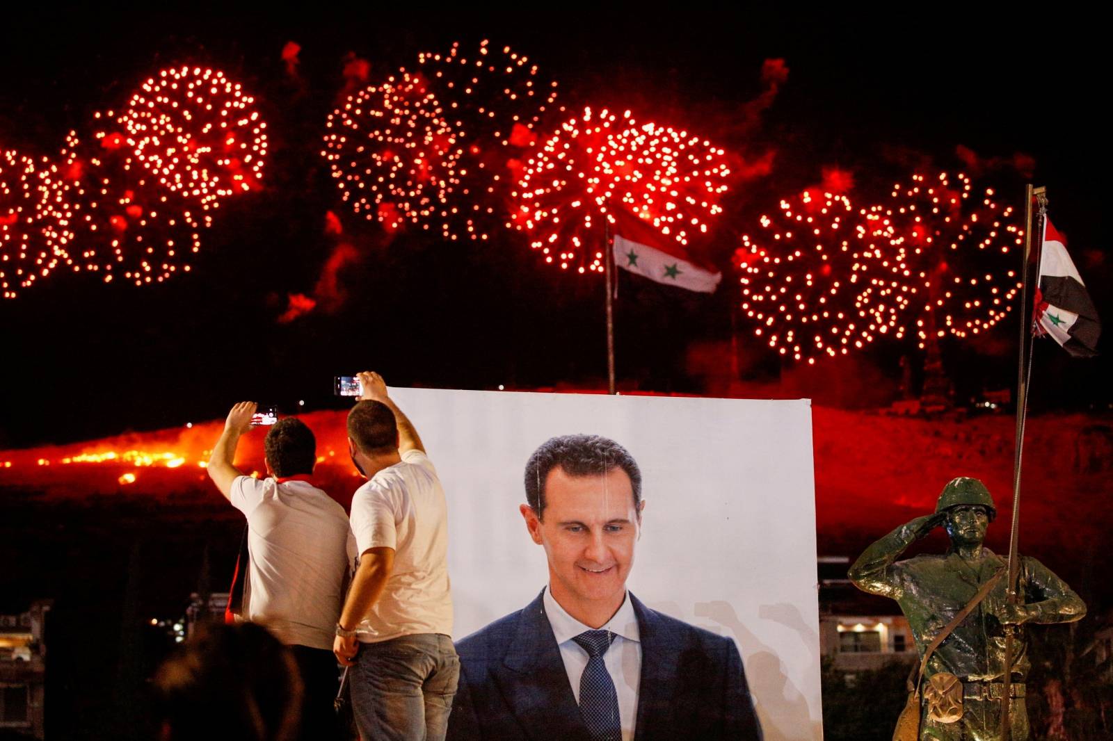 Supporters of Syria's President Bashar al-Assad celebrate after the results of the presidential election announced that he won a fourth term in office, in Damascus