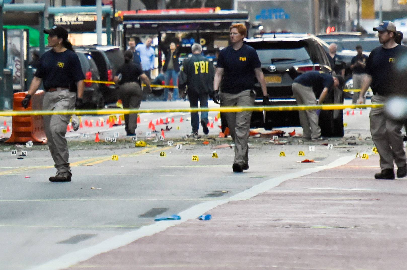 FBI officials walk past evidence markers near site of explosion in New York