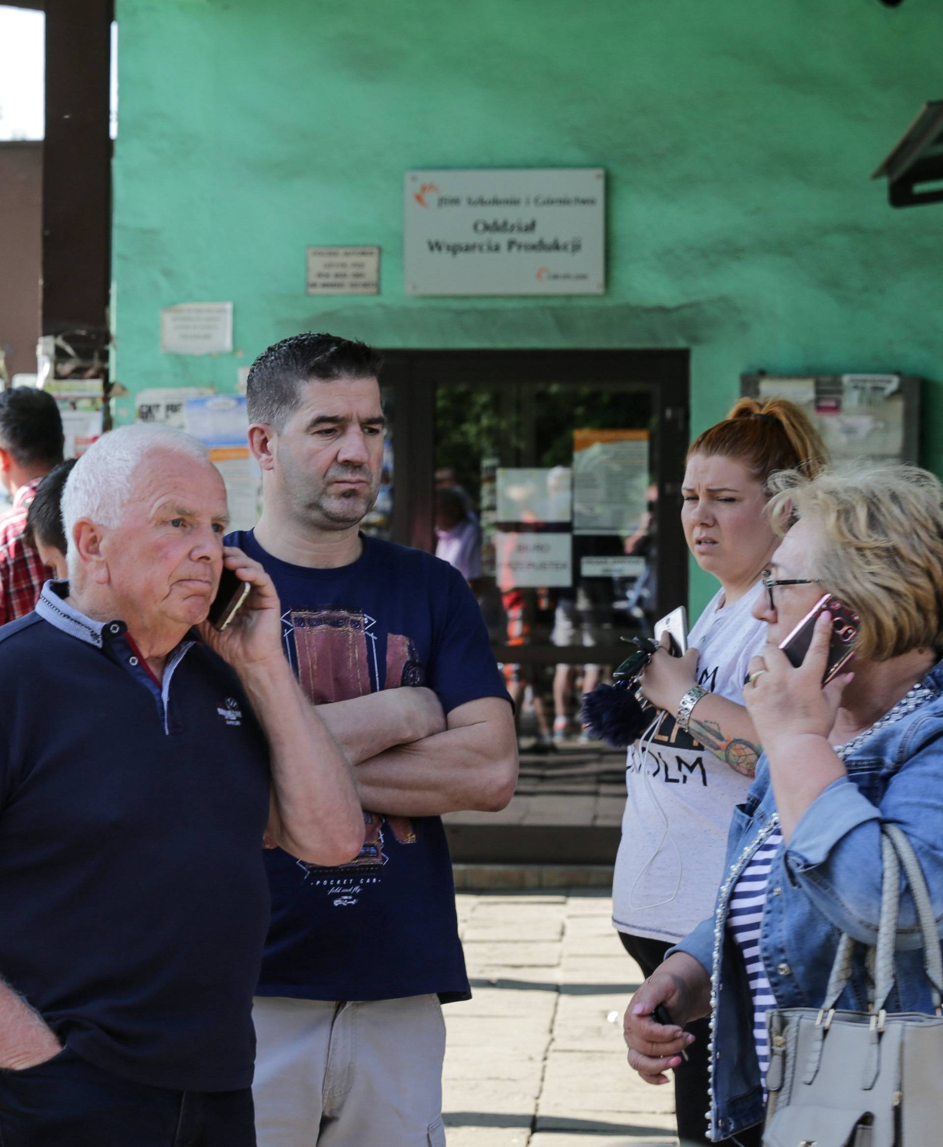 People wait outside the JSW mine where coal miners are missing underground after a strong quake hit a mine in Jastrzebie Zdro