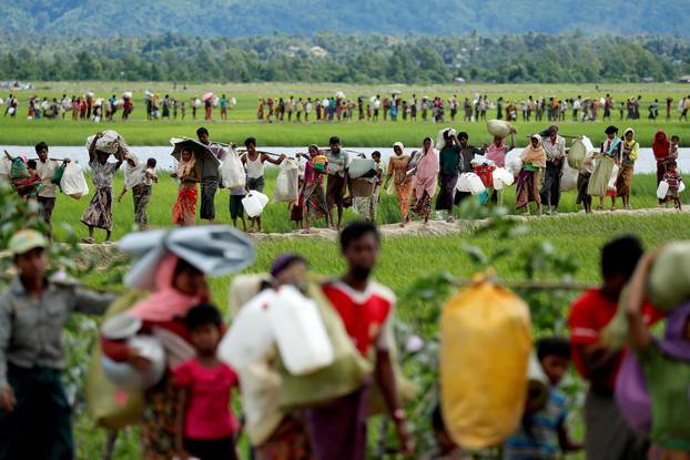 FILE PHOTO: Rohingya refugees walk after they received permission from the Bangladeshi army to continue on to the refugee camps, in Palang Khali