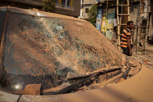 A man stands next to a damaged vehicle in a neighbourhood, following Pakistan's military operation against India, in Rehari, Jammu