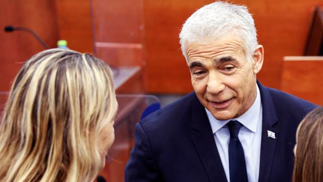 Israeli opposition leader Yair Lapid speaks to people at the Jerusalem District Court before he is due to testify in Prime Minister Benjamin Netanyahu's corruption trial in Jerusalem