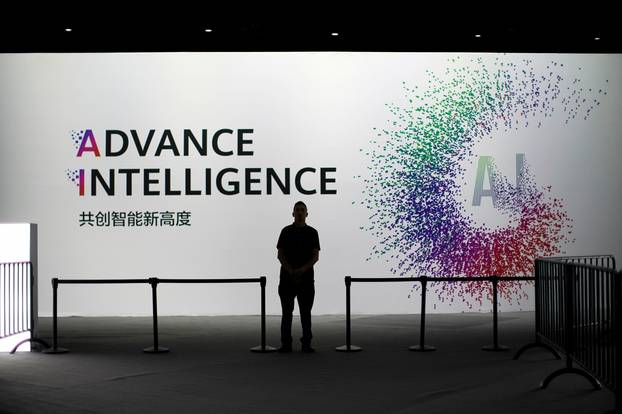 FILE PHOTO: A security officer keeps watch in front of an AI (Artificial Intelligence) sign at the annual Huawei Connect event in Shanghai