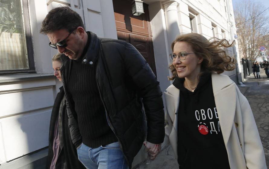Presidential candidate Sobchak and her husband Vitorgan walk after visiting a polling station during the presidential election in Moscow