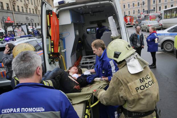 An injured person is helped by emergency services outside Sennaya Ploshchad metro station following explosions in St. Petersburg