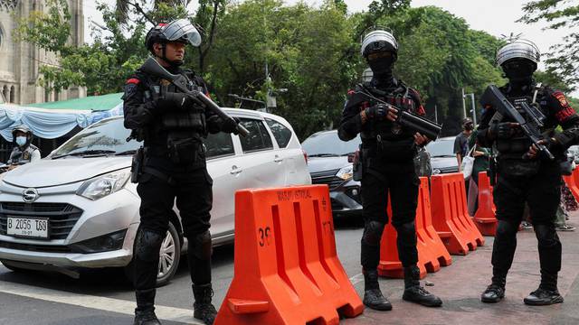 Riot police officers stand guard outside Jakarta Cathedral ahead of the Christmas Mass in Jakarta