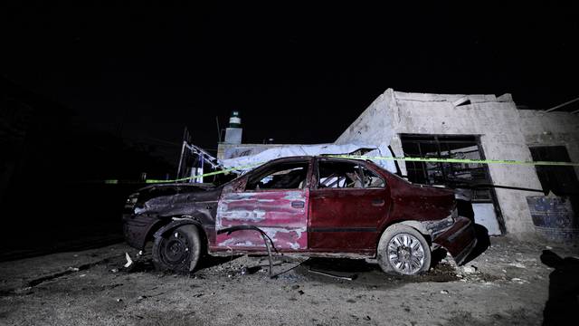 A damaged car is pictured after an explosion in Kafr Sousa neighborhood of Damascus