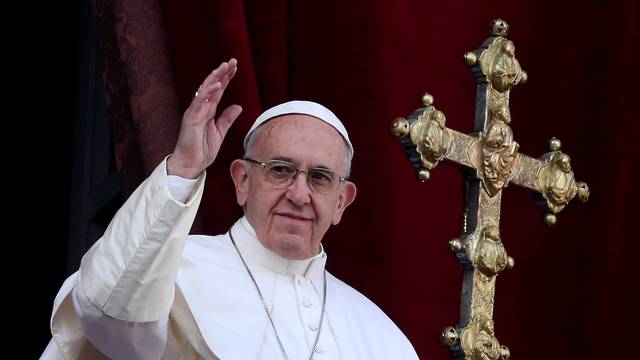 Pope Francis waves after delivering his "Urbi et Orbi" (to the city and the world) message from the balcony overlooking St. Peter's Square at the Vatican
