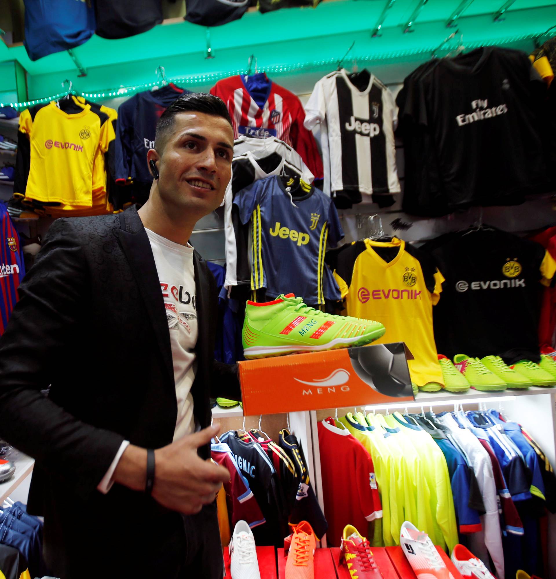 Biwar Abdullah, 25, an Iraqi Kurdish local footballer, who looks like the football player Cristiano Ronaldo, pose for a pictures at a sportswear shop in the district of Soran, northeast of Erbil