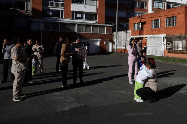 People gather outside a building following an earthquake in Bogota