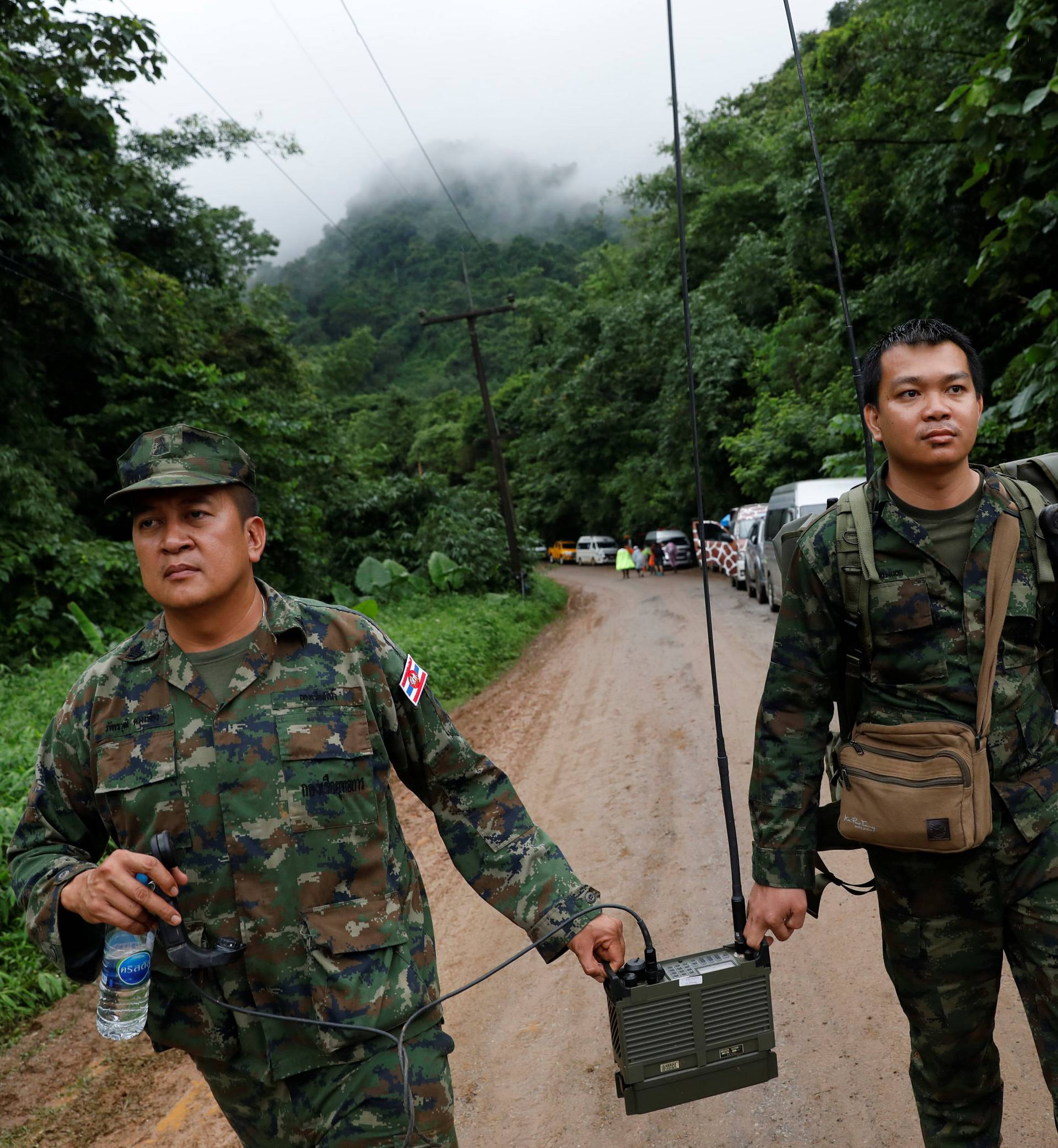 Soldiers carry a radio near Tham Luang cave complex during a search for members of an under-16 soccer team and their coach, in the northern province of Chiang Rai