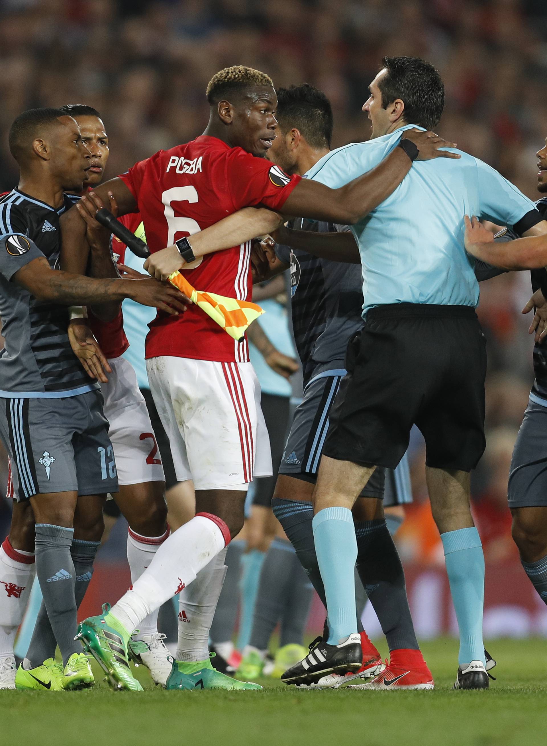 Manchester United's Paul Pogba clashes with Celta Vigo's Facundo Roncaglia as referee Ovidiu Hategan intervenes