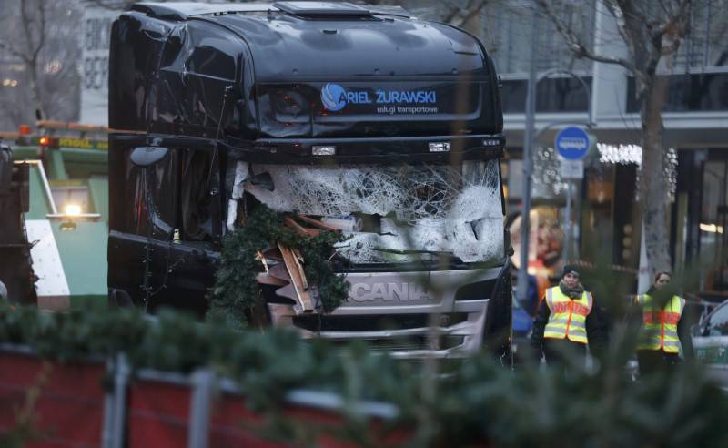 Police walks past the truck which ploughed into a crowded Christmas market in the German capital last night in Berlin