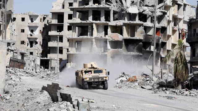 An armoured vehicle of the Syrian Democratic Forces is seen along a road at the frontline in Raqqa