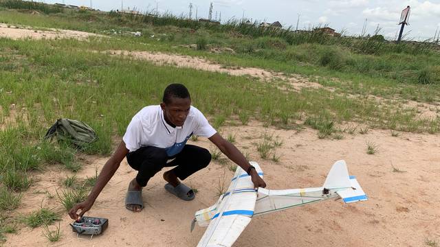 Bolaji Fatai prepares to fly a model aeroplane made from discarded waste in Lagos