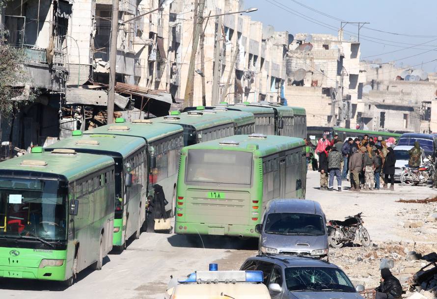 People get on buses to be evacuated from al-Sukkari rebel-held sector of eastern Aleppo
