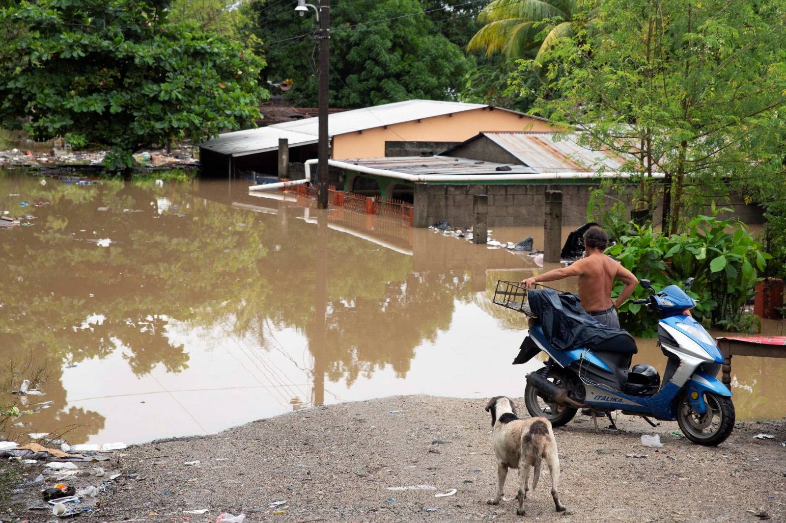 Man looks at houses at an area flooded by the Chamelecon river after the passing of Storm Iota, in La Lima