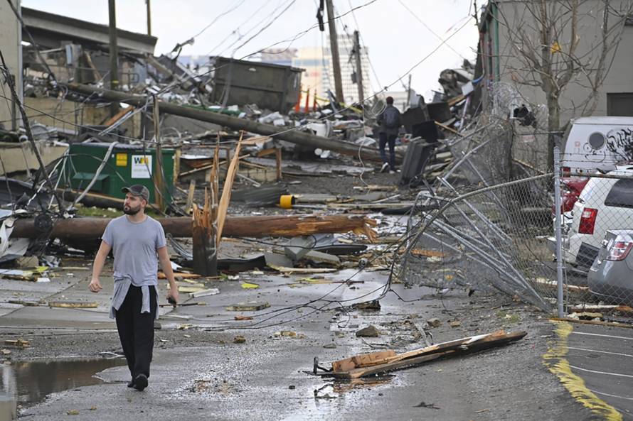 A man views damage in an alley behind Woodland Street after a tornado touched down in Nashville