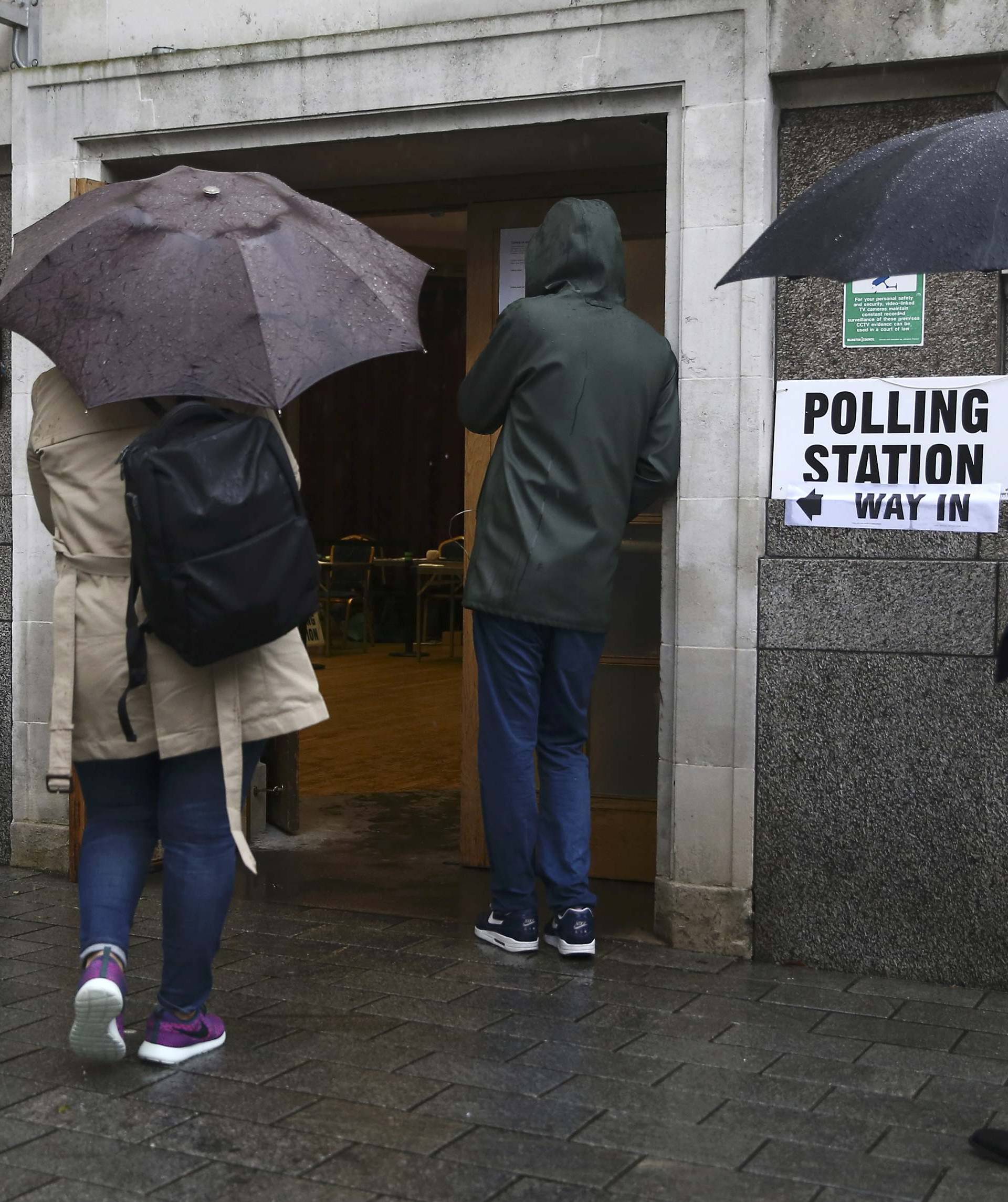 People queue in the rain outside a polling station for the Referendum on the European Union in north London, Britain