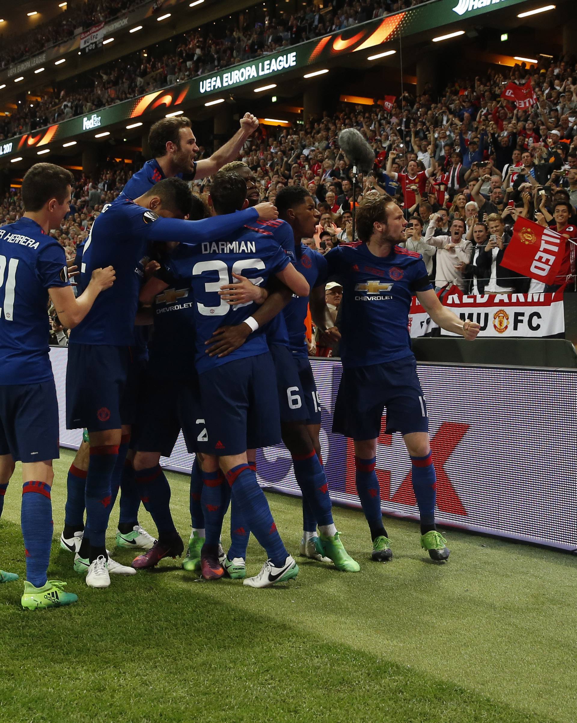 Manchester United's Henrikh Mkhitaryan (hidden) celebrates scoring their second goal with team mates