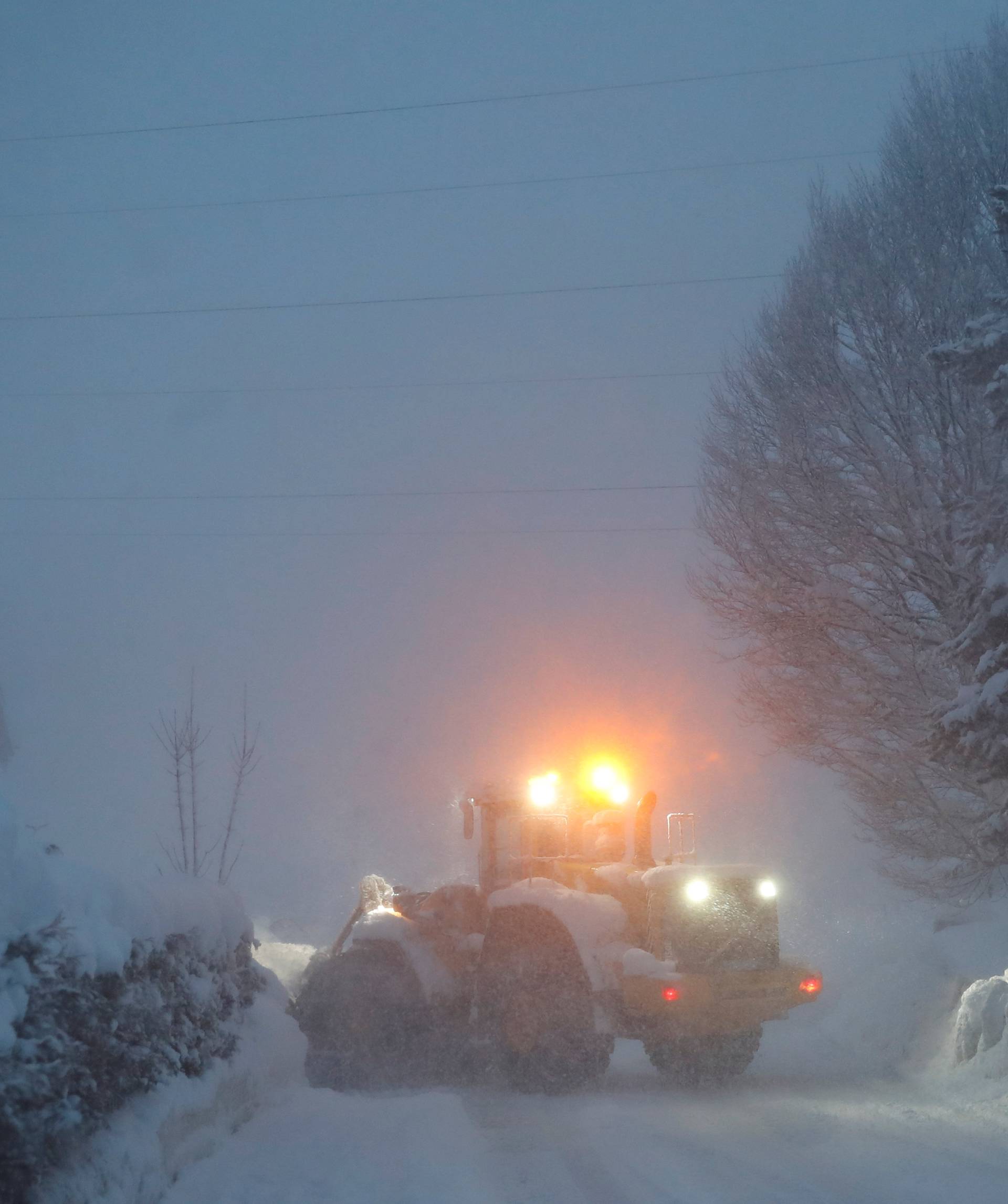 A vehicle removes snow from a road during heavy snowfall in Reitdorf