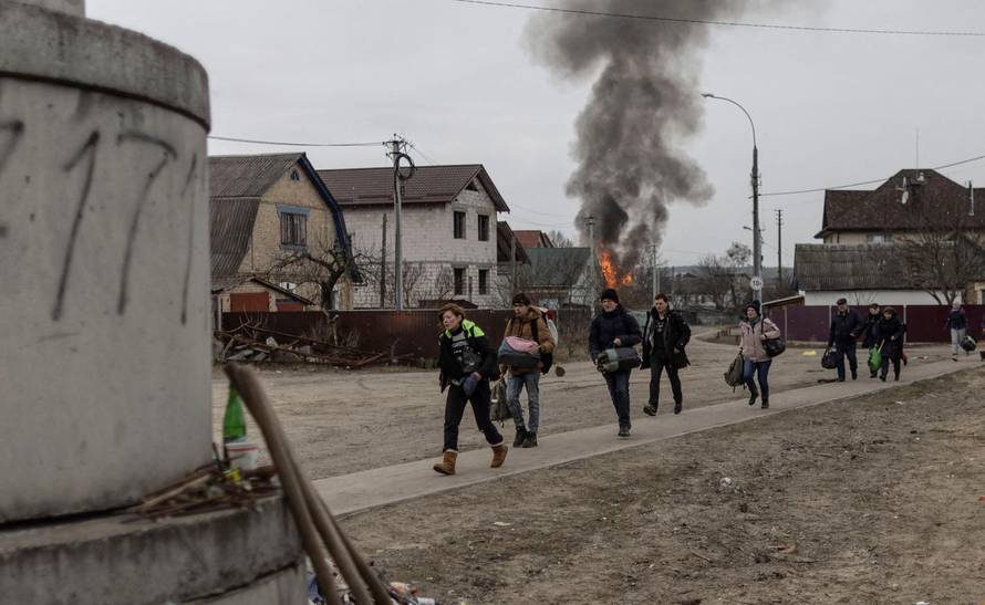 Local residents escape from the town of Irpin, after heavy shelling landed on the only escape route used by locals, as Russian troops advance towards the capital of Kyiv, in Irpin