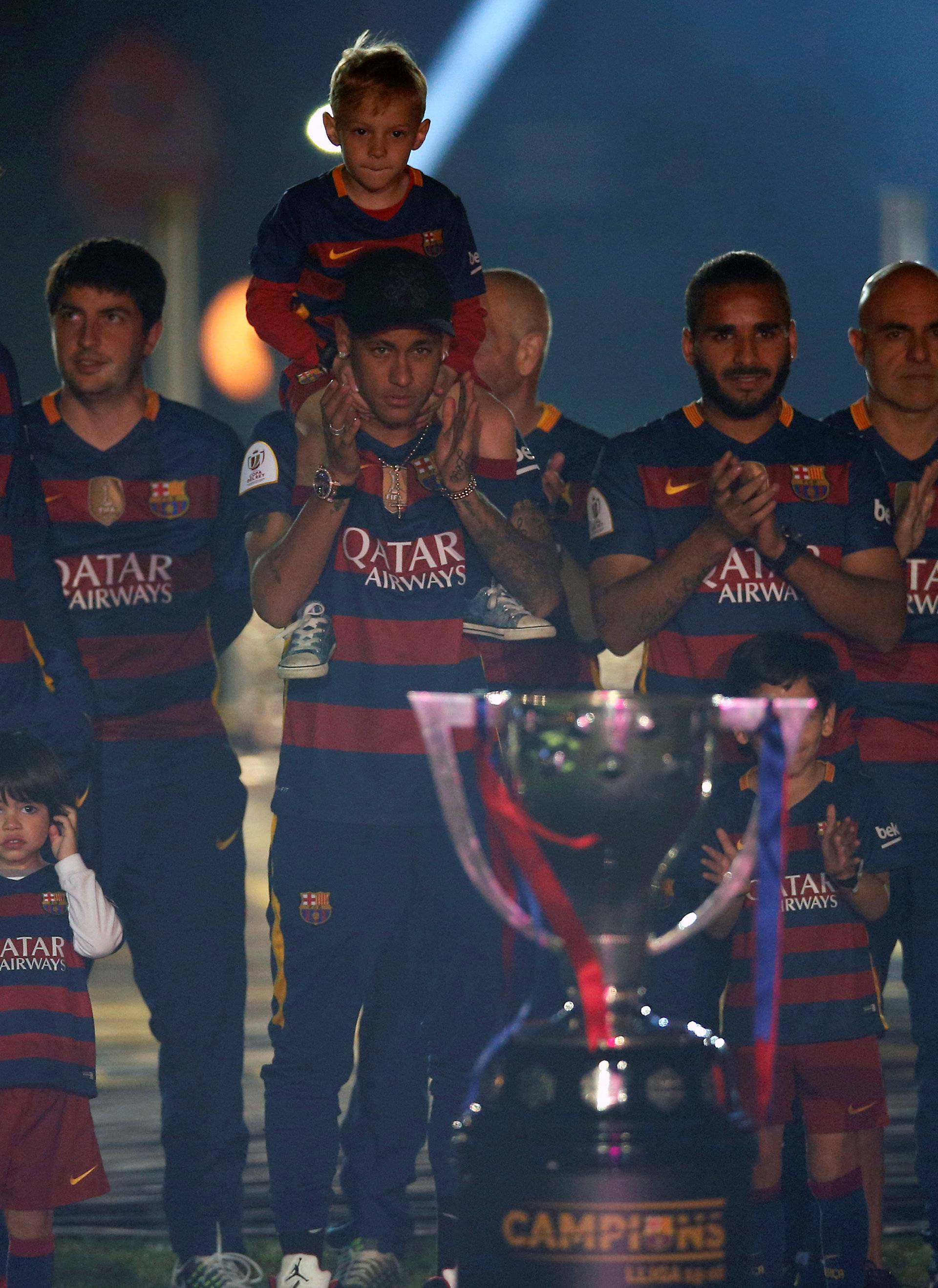 Barcelona's players and staff members, with their families, pose with their season's trophies at Camp Nou stadium in Barcelona