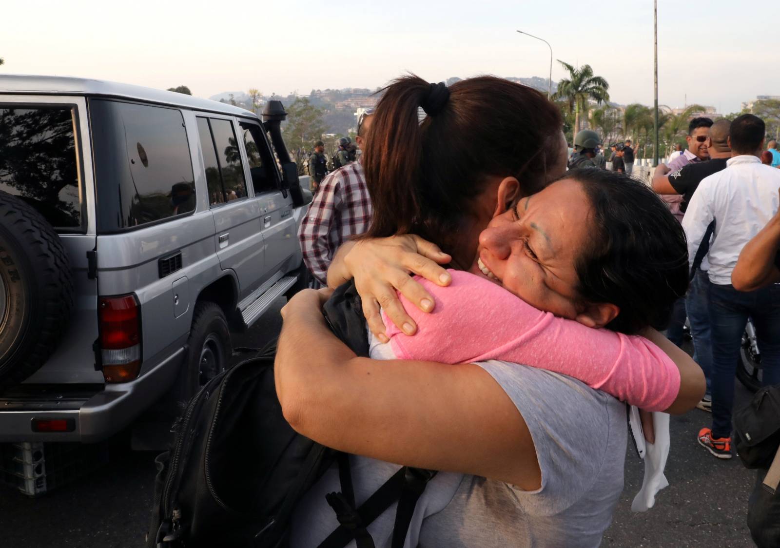 Opposition supporters hug near the Generalisimo Francisco de Miranda Airbase in Caracas