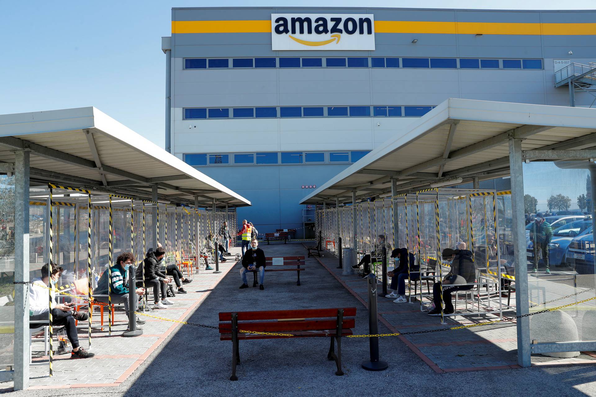 Workers relax during a break outside Amazon's distribution centre in Passo Corese