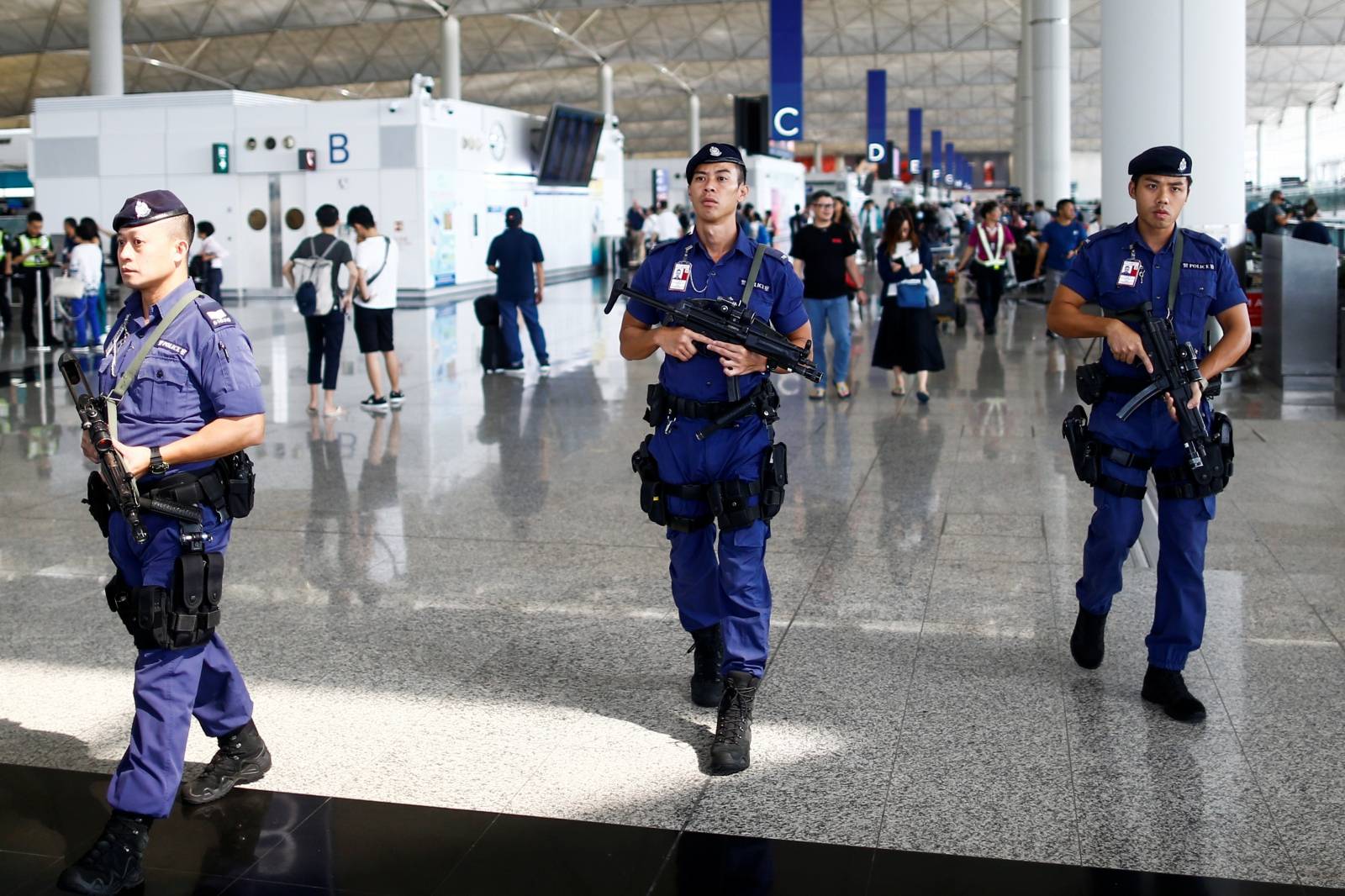 Armed police patrol the departure hall of the airport in Hong Kong after previous night's clashes with protesters