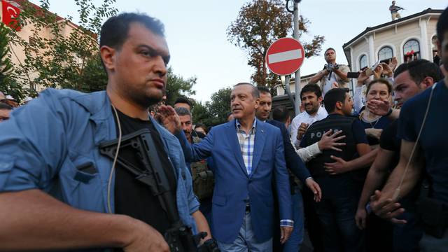 Turkish President Tayyip Erdogan walks through the crowd of supporters protected by bodyguards in Istanbul