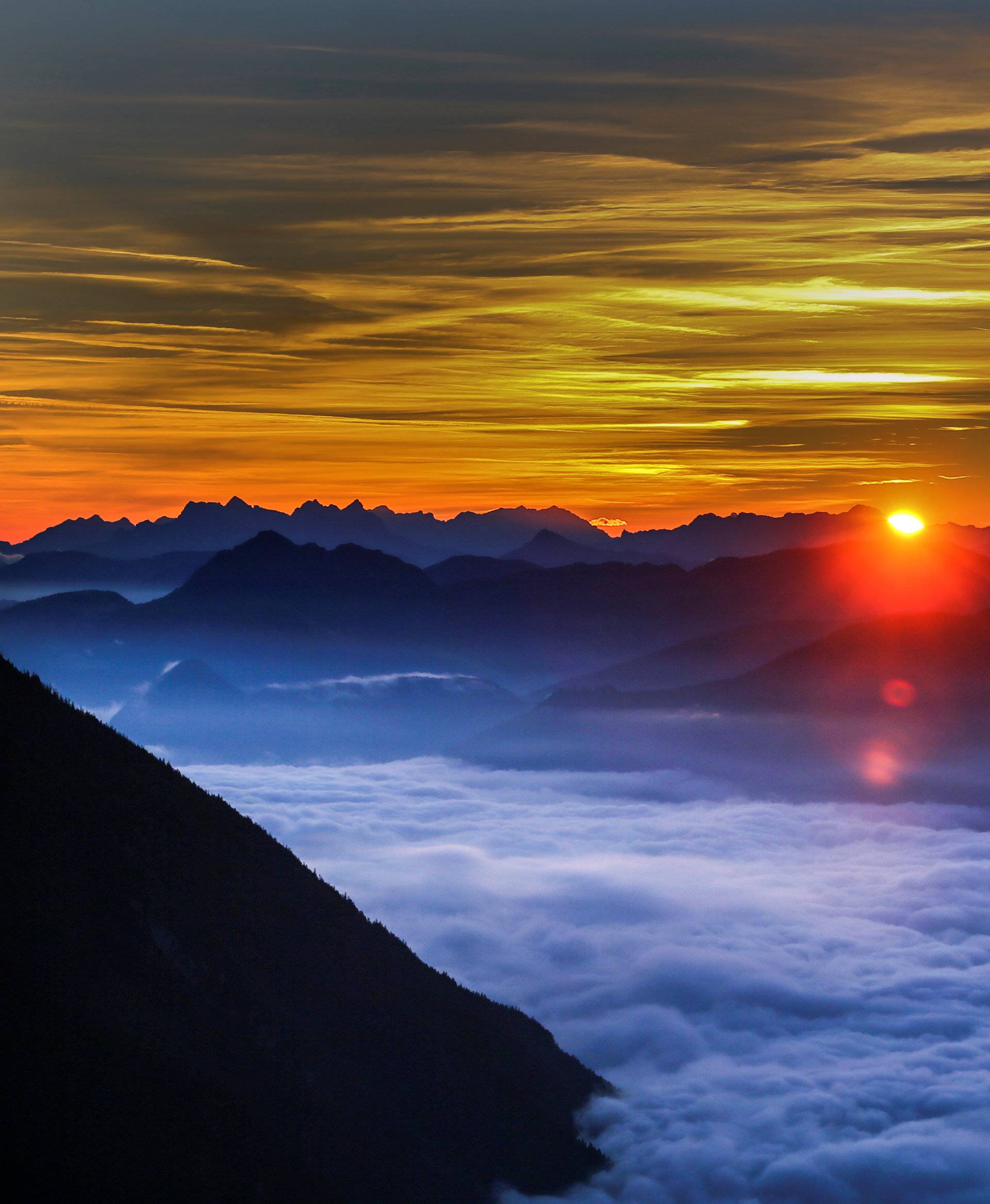 Fog covers the Inntal valley as the sunrise is seen from the Hundskopf mountain in the western Austrian village of Gnadenwald