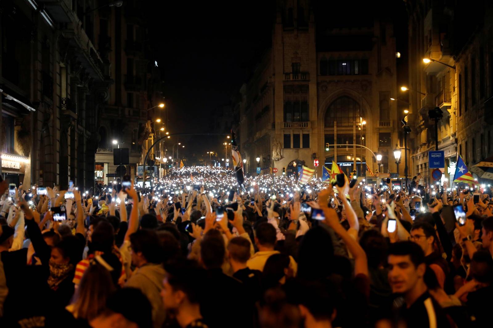 Demonstrators hold up their phones during a protest after a verdict in a trial over a banned independence referendum, in Barcelona