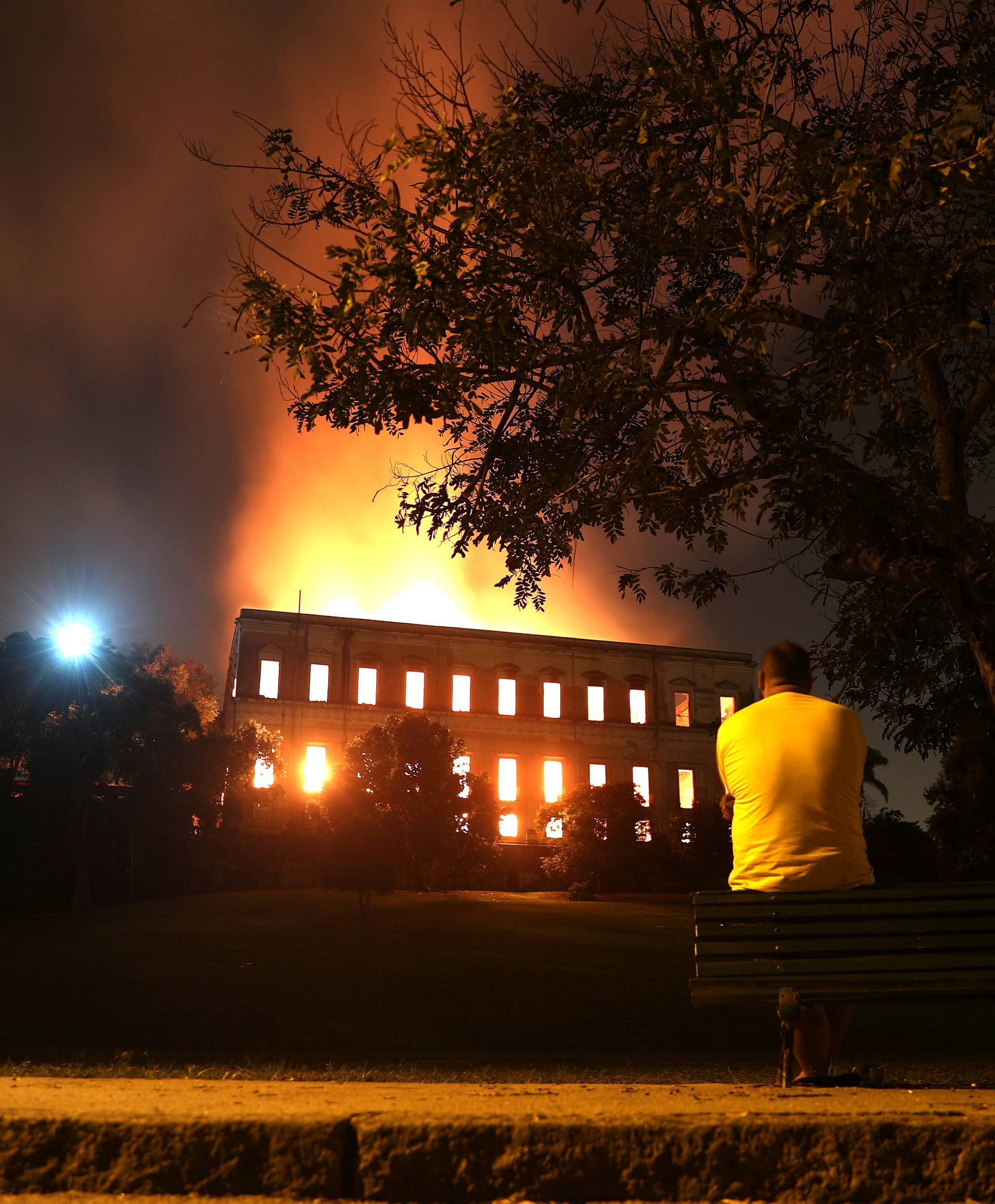 A man watches as a fire burns at the National Museum of Brazil in Rio de Janeiro