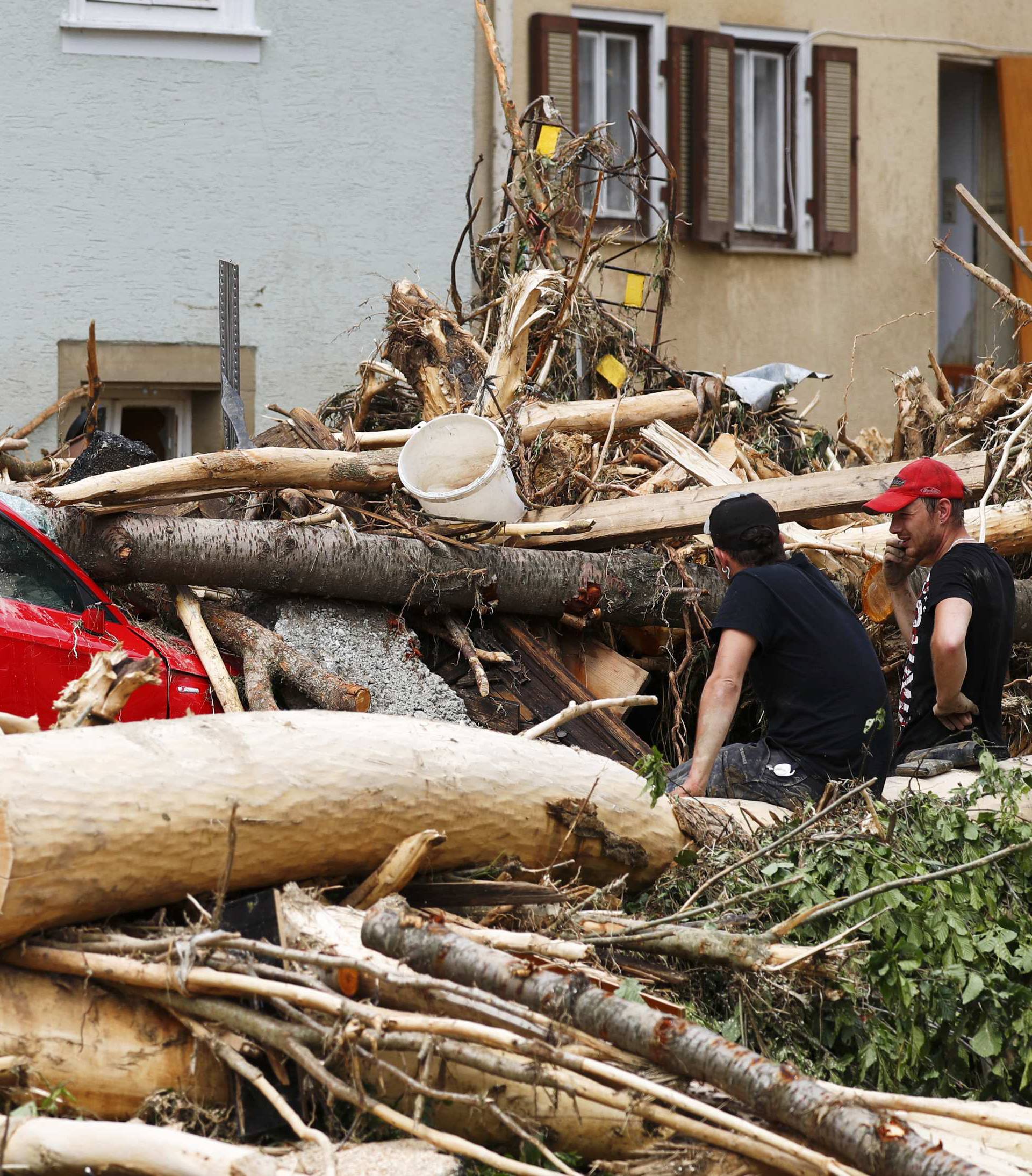 People damage damage caused by the floods in the town of Braunsbach in Baden-Wuerttemberg