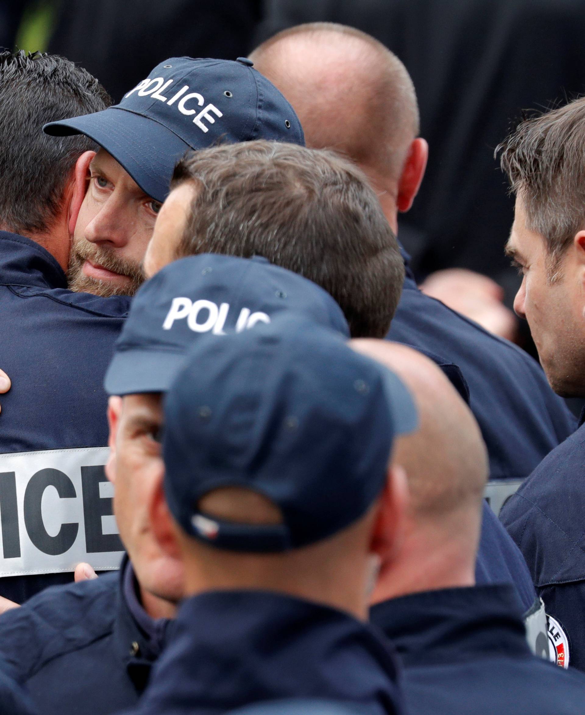 Police officers react at the end of a memorial ceremony honouring the slain police couple in Versailles